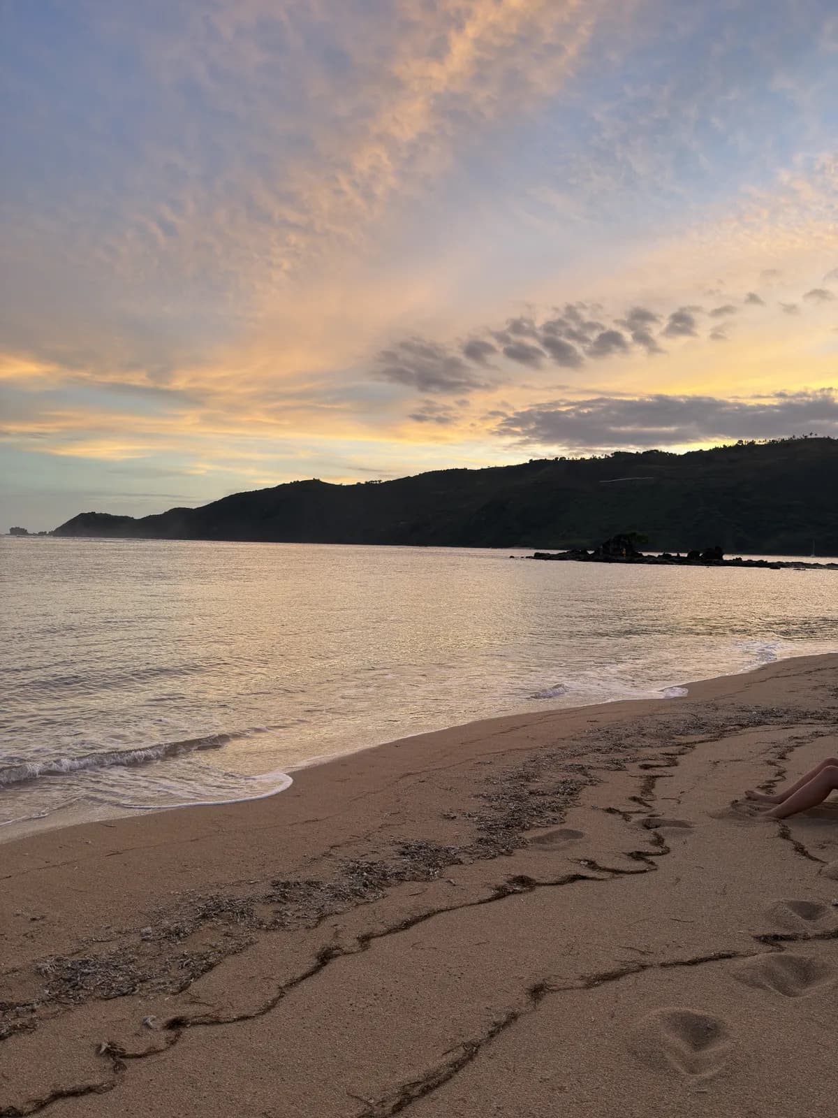 Beach at sunset with footprints in the sand